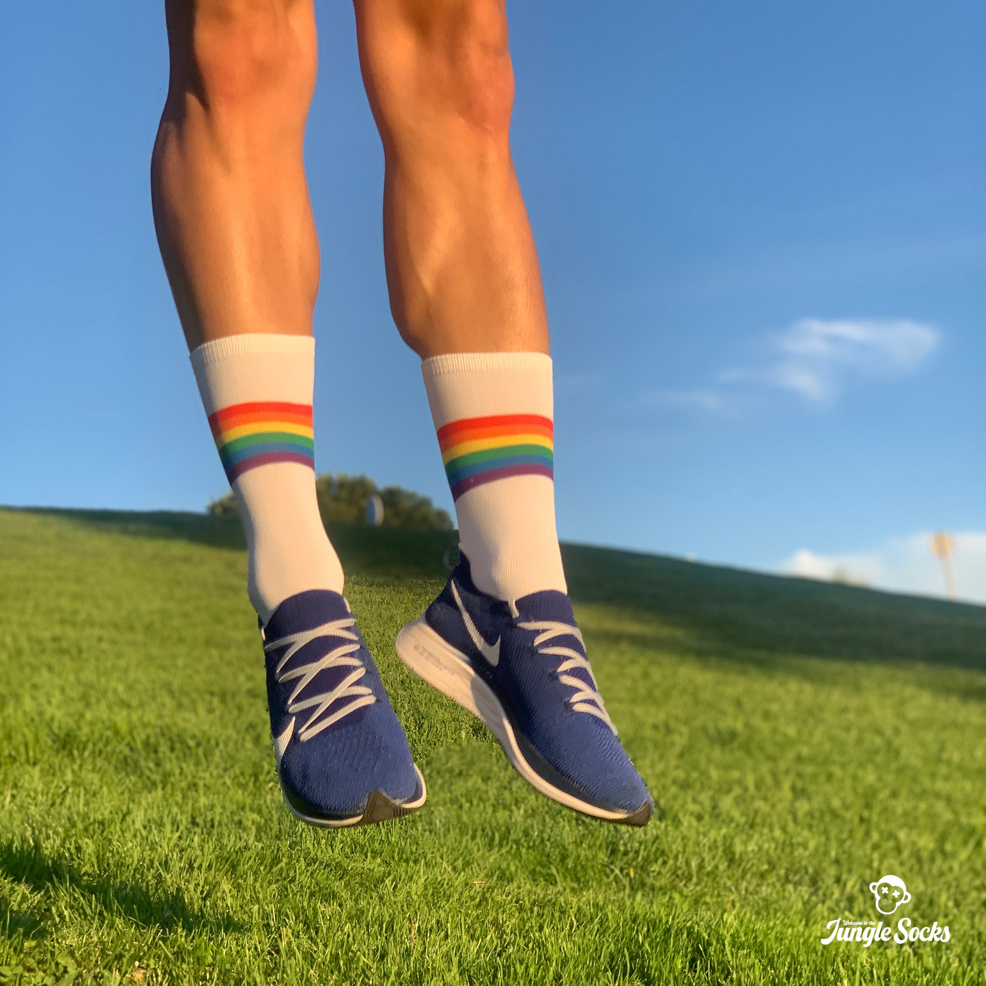 Hombre saltando con calcetines deportivos divertidos con la bandera del orgullo